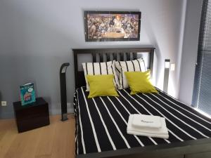 a bedroom with a bed with two yellow pillows at Villa Gayac in Gradignan