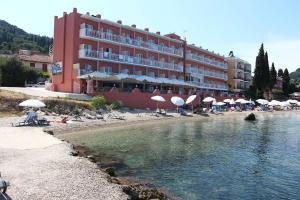 un hotel su una spiaggia con ombrelloni e acqua di Nona's Guest House Corfu Βenitses a Benitses