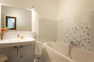 a white bathroom with a sink and a tub and a sink at La Chiantata - Abbasciu in San Vito dei Normanni