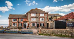 a brick house on the side of a street at The Ship Inn in Mundesley