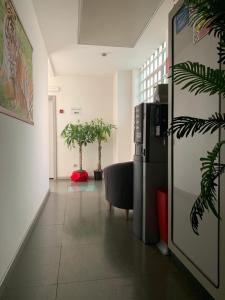 a hallway with two potted plants and a refrigerator at Hotel Lucania in Milan