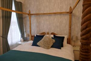 a bedroom with a bed with blue and white pillows at The Boundary in Scarborough