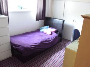 a bedroom with a bed with purple sheets and pillows at Nottingham City House in Nottingham