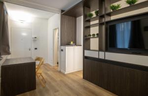 sala de estar con TV de pantalla plana y cocina en Madonnina Apartment, en Milán