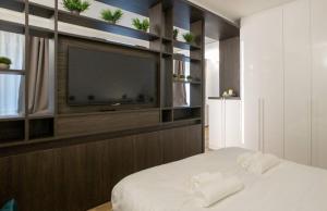 Schlafzimmer mit einem Flachbild-TV und einem Bett in der Unterkunft Madonnina Apartment in Mailand
