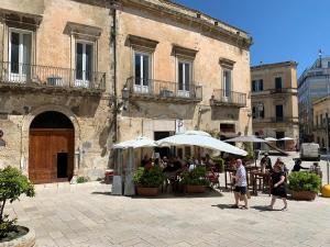 a group of people standing under umbrellas in front of a building at Buon Consiglio B&B in Lecce