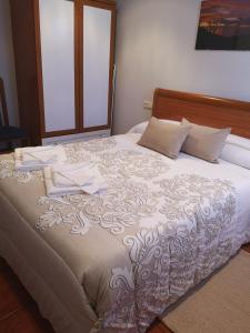 1 cama grande con sábanas y almohadas blancas en Apartamentos La Tarazana 4 en La Pereda de Llanes