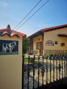 una cerca frente a un edificio con una foto de una vaca en Apartamentos La Tarazana 4 en La Pereda de Llanes