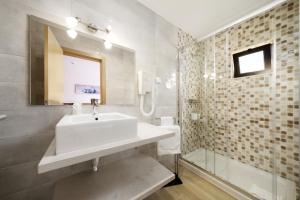 a bathroom with a tub, sink and mirror at Quinta das Andorinhas in Carvoeiro
