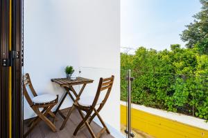a balcony with a table and two chairs and a window at Quinta das Andorinhas in Carvoeiro
