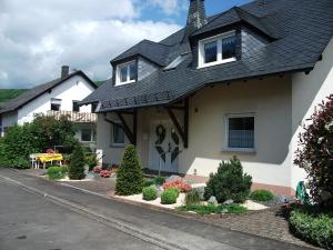 uma casa branca com um telhado preto em Appart-Pension-Schier em Zell an der Mosel