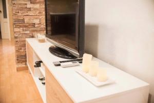 a white counter with a tv and candles on it at NICE HOME city center in Melilla
