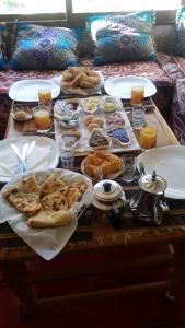 a table with plates of food on top at Maison D'hote Chez La Famille in Tamellalt