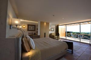 a hotel room with a bed and a balcony at A Serenada Enoturismo in Grândola