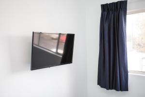 a flat screen tv hanging on a wall next to a window at Ocean Park Hotel in Los Angeles