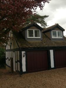 uma garagem castanha e branca com uma janela em cima em Round-y-Corner em Macclesfield