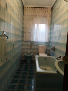 a bathroom with a tub and a toilet and a sink at Casa de la Riva in Trobajo del Camino