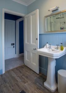 a bathroom with a sink and a mirror and a toilet at Number 8 Cheltenham in Cheltenham