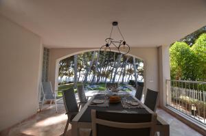 a dining room with a table and chairs on a balcony at Villa Ginesta 7 in Alcudia