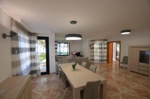 a dining room and living room with a table and chairs at Villa Ginesta 7 in Alcudia
