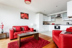sala de estar con sofá rojo y mesa en Purbecks, en Poole
