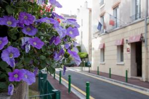 a bunch of purple flowers hanging from a tree at Hôtel du Parc in Malakoff