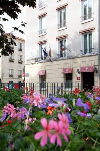 einen Blumengarten vor einem Gebäude in der Unterkunft Hôtel du Parc in Malakoff