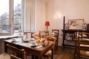 d'une salle à manger avec une table, des chaises et une fenêtre. dans l'établissement Hôtel Londres Saint Honoré, à Paris