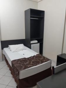 1 dormitorio con 1 cama con cabecero negro en Hotel Express - Leva e busca no aeroporto grátis 24 horas, en Várzea Grande