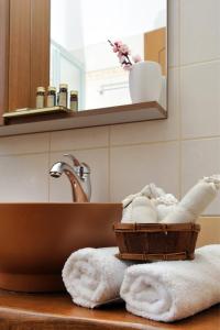 a bathroom with a sink and a basket of towels at Guesthouse Kapaniaris in Zagora