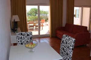 een woonkamer met een tafel met een fruitschaal erop bij Flats - Duna Parque Group in Vila Nova de Milfontes