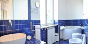 bagno piastrellato blu con vasca e servizi igienici di Tenuta Le Fornacelle a Torre del Greco