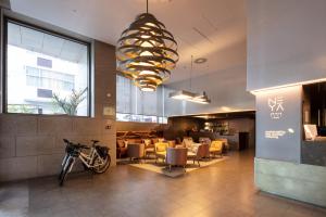a lobby with a restaurant with chairs and a chandelier at NEYA Lisboa Hotel in Lisbon