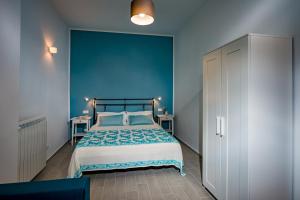 - une chambre dotée d'un lit avec un mur bleu dans l'établissement Annina'S Home, à Castellammare del Golfo
