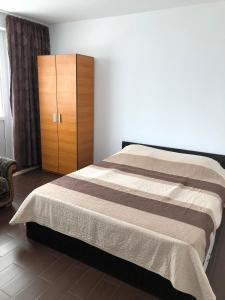 Schlafzimmer mit einem Bett und einem Holzschrank in der Unterkunft Apartament Marian Mangalia in Mangalia