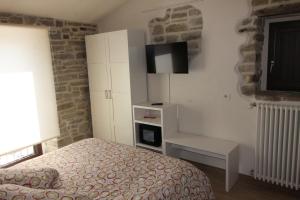 a bedroom with a bed and a tv on the wall at MIRUTT by Keyhole Selection in Castelmezzano