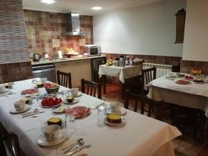 un comedor con dos mesas con comida. en Casa Rural Altzibar-berri, en Urnieta