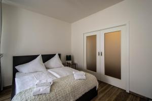 ein Schlafzimmer mit einem Bett mit weißer Bettwäsche und einer Tür in der Unterkunft Unique Charles Bridge 2BDR Apartment. in Prag