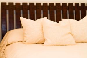 1 cama con almohadas blancas y cabecero de madera en Apartament Kopernik, en Cracovia