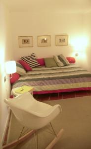 a bedroom with a bed and a white chair at Oliveirinha in Lisbon