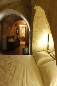 ein Schlafzimmer mit einem Bett in einer Steinmauer in der Unterkunft Casa Linda in Matera