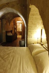 Un dormitorio con una cama en una pared de piedra. en Casa Linda, en Matera