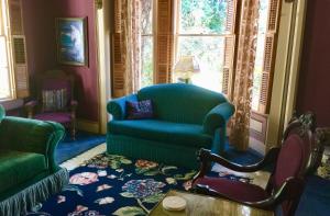 a living room with a green couch and a chair at Shaw House Inn in Ferndale