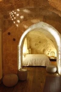 Un dormitorio con una cama en una habitación de piedra. en Casa Linda, en Matera