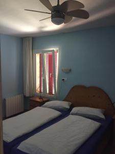 a bedroom with two beds and a ceiling fan at Residencial Playa Mar in Cala Mendia