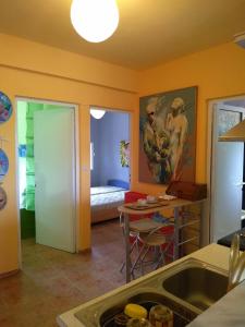 een keuken met een wastafel en een tafel in een kamer bij House of colors in Néa Meságkala