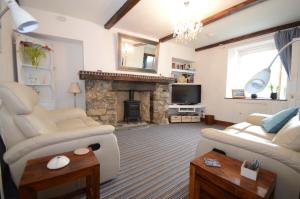 uma sala de estar com um sofá e uma lareira em Driftwood Cottage em Banff