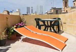 un patio con tavolo e sedie sul balcone. di 6 a Birgu (Vittoriosa)