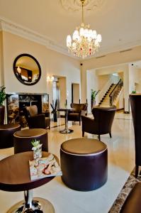 una hall con sedie, tavoli e lampadario a braccio di Hotel Edward Paddington a Londra