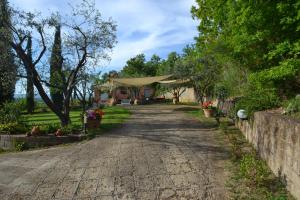 a driveway leading to a house with a tent at Il Pungitopo in Manciano